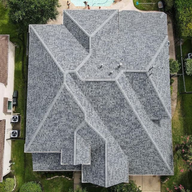 An aerial view of a house with a shingled roof.