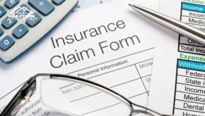 A close-up view of an insurance claim form with a pen and eyeglasses on top.