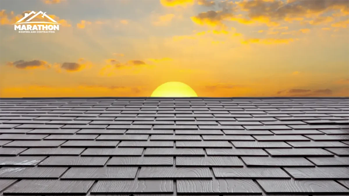 A shingled roof with the sun setting behind it.